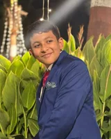 Safal in a navy blazer and red tie, smiling